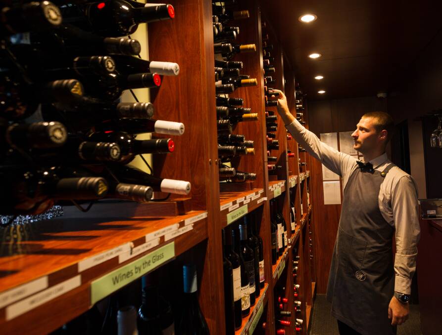 SPOILED FOR CHOICE: Bartender Sam Mcenerny selecting a wine.