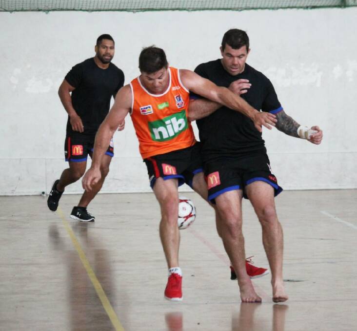 ON TRACK: Josh Starling (right) challenges reserve grade coach Simon Woolford for the ball in a game of indoor soccer. Picture: Newcastle Knights 