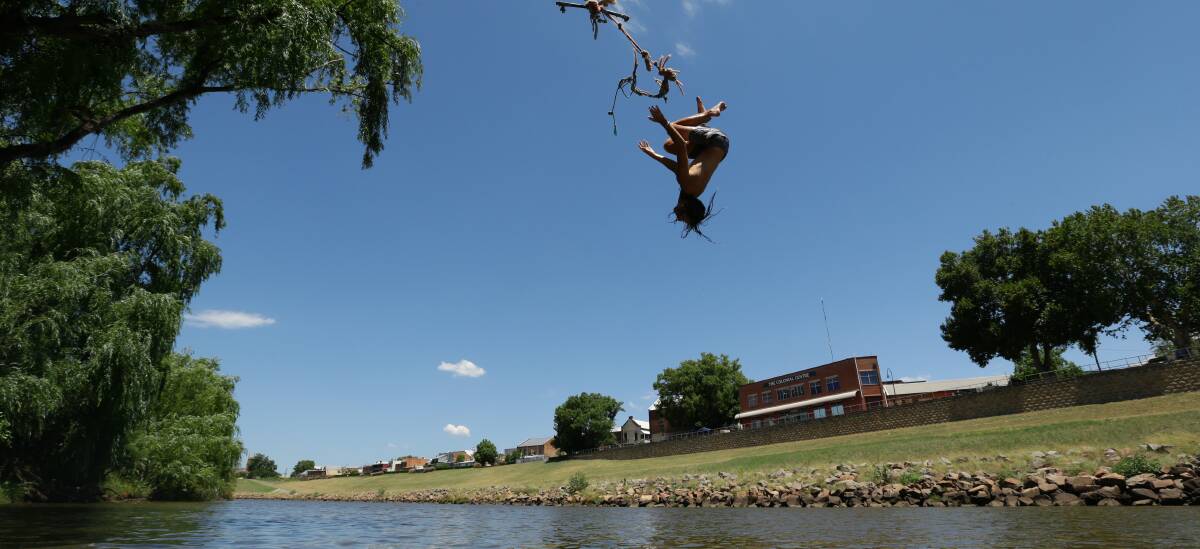 COOL OFF: 14-year-old Dyllan Hector swings from a rope on the Lorn side into the Hunter River on Tuesday. Picture: Jonathan Carroll