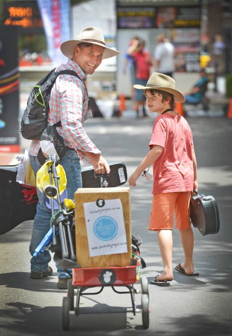 ROLLIN' ON IN: Jonah, 8, and busker James Cummins on Peel Street, Tamworth in 2016. Picture: Barry Smith