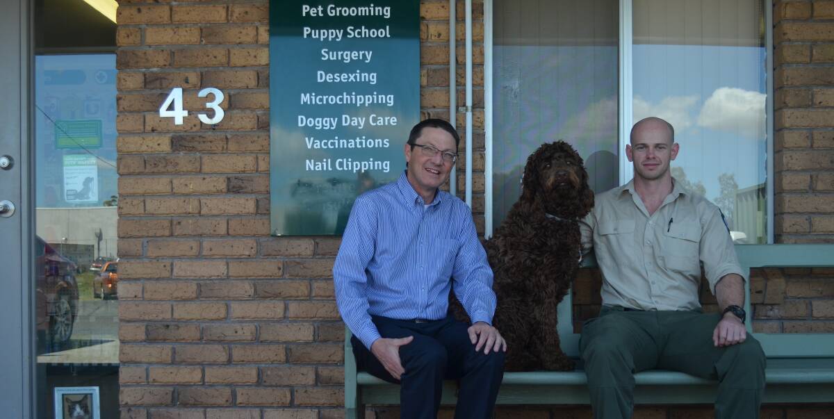 MAN'S BEST FRIEND: Scot MacDonald, the Parliamentary Secretary for the Hunter, with Brodie the golden retriever-poodle, and Port Stephens Council ranger Chris Marshall. Picture: Sam Norris