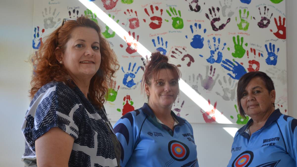 HELPING HANDS: Raymond Terrace Health Centre clinical integration coordinator Megan Alston has praised the work of Wahroonga Aboriginal Corporation support worker Janelle Wood and executive director Dianne Ball. They're pictured with the artwork of previous Koori Youth Health Workshop participants. Picture: Sam Norris 