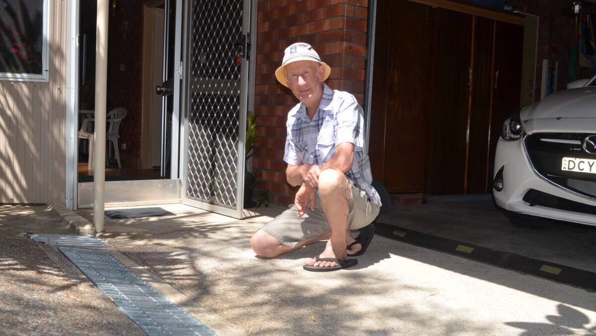 STORWATER MEASURE: Heinz Kruger lives on the low side of Leonard Street, Shoal Bay. An upgraded strip drain, door plate and speed bump are only part of an elaborte system devised to cope with runoff. Picture: Sam Norris