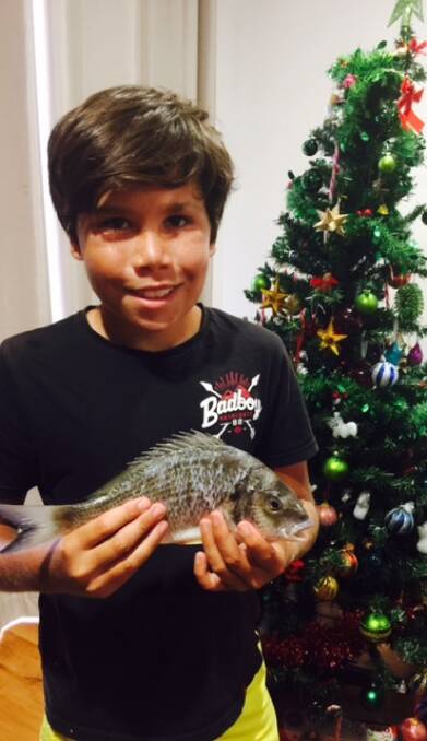 GREAT PRESENT: Young Ian Beale with his first fish. The mighty bream was caught at Soldiers Point.