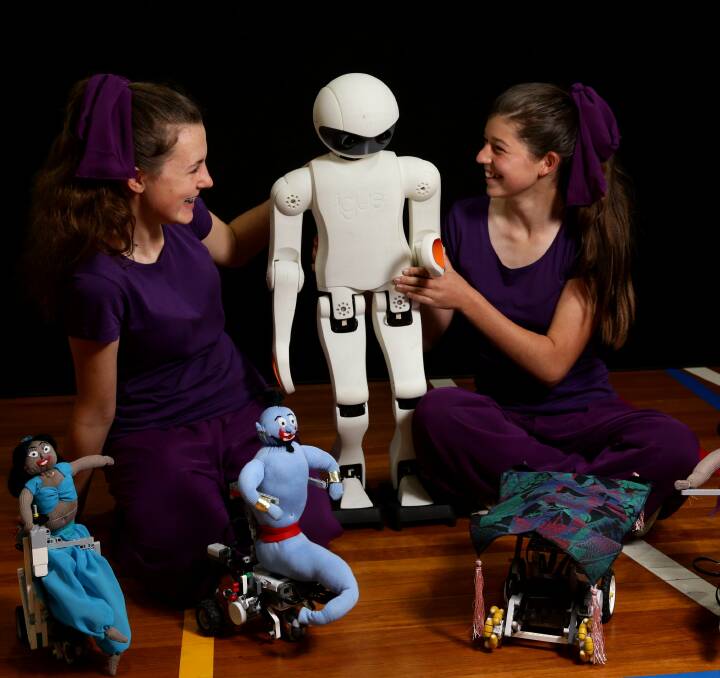 Robot world:Newcastle High students, Jacqui Flood, left, and Kahlee Taylor, with their robot Igus, centre, and Aladdin themed robots in front. Picture: Jonathan Carroll