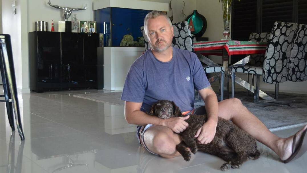 FIGHT: Nathan Wilson, with curly haired retriever Charlotte, demanded answers after the death of his greyhound in a Fullerton Cove boarding kennel.