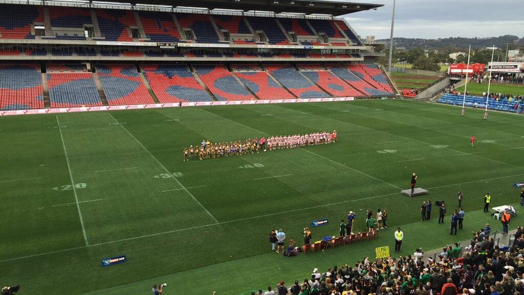 GRAND STAGE: Macquarie and South Newcastle teams line up for the national anthems before kick off at Hunter Stadium. Picture: Josh Callinan.