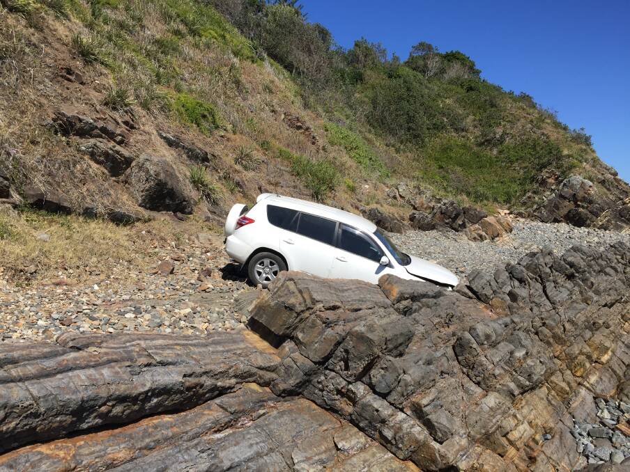 ON THE ROCKS: Police said boulders stopped the vehicle from reaching the ocean after tumbling down the slope. The occupants avoided serious injury after the RAV4 fell roughly 20 metres from the lookout. Picture: Rob Douglas