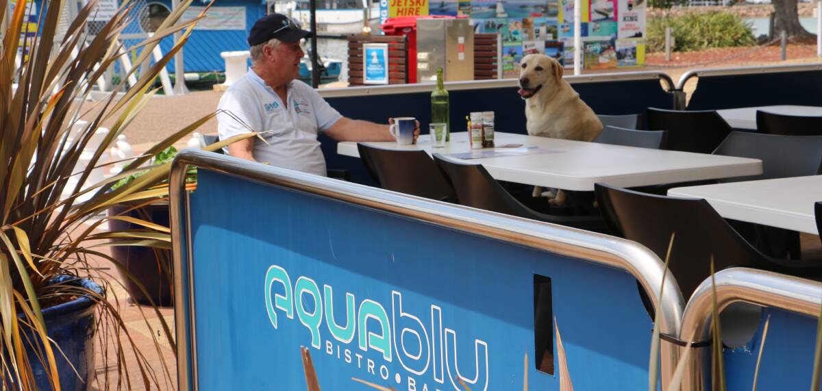 Ian Cutbush, from Port Stephens Watersports, enjoying a coffee at AquaBlu with his dog Brandy.