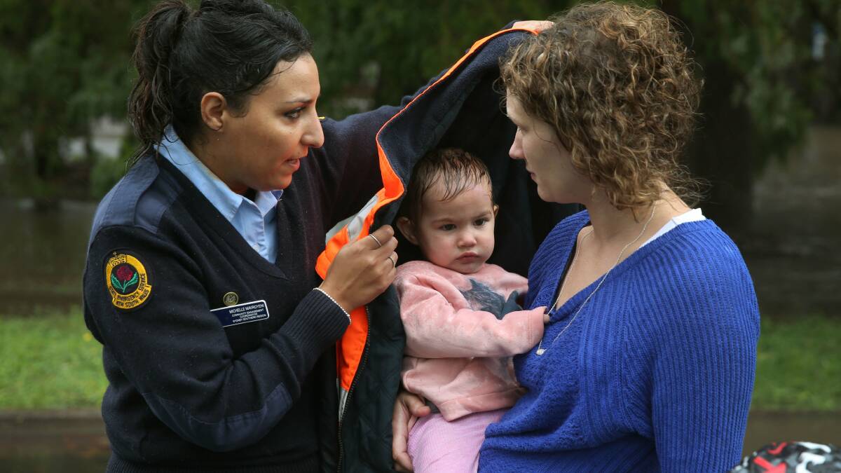 SAFE: Raymond Terrace resident Rochelle Wright and daughter Amelia, 1, with Michelle Mavroyeni from NSW SES on Wednesday, January 6. The Wright family was evacuated from Hunter Street on Wednesday. Picture: Marina Neil
