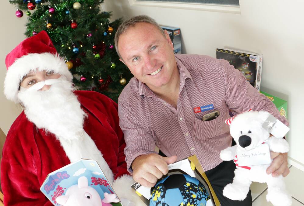 JOLLY: Michelle Bink, dressed as Santa, and Craig Higgins from Dowling Real Estate Raymond Terrace. Picture: Stephen Wark