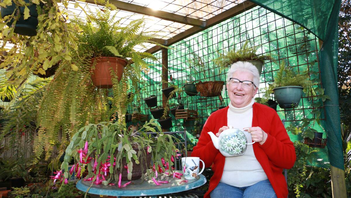 PAINTER: Raymond Terrace artist Florence Humphreys sitting in her garden with her hand-painted teapot and cup. Picture: Ellie-Marie Watts