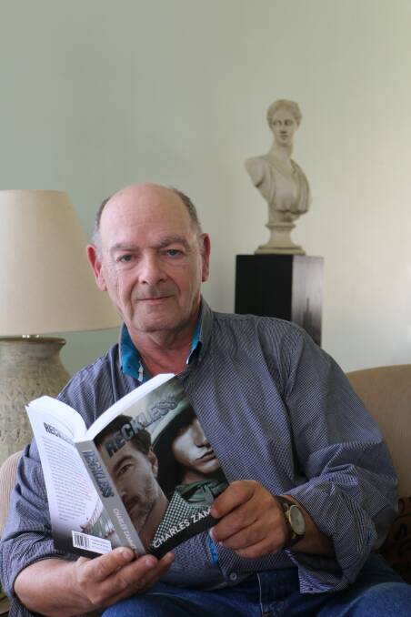 Charles Zammit with his book, Reckless, in his home of Raymond Terrace. Picture: Ellie-Marie Watts