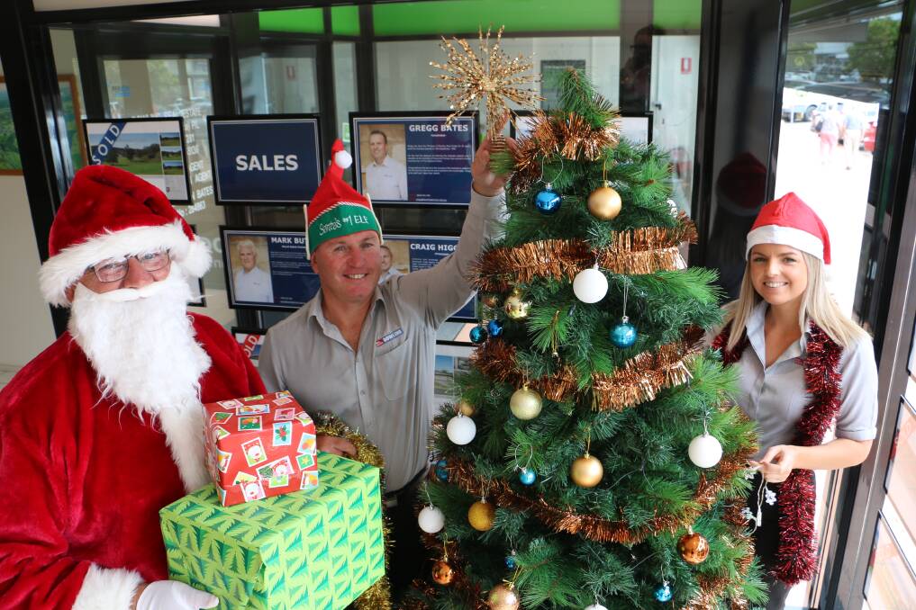 CHRISTMAS SPIRIT: Santa with Dowling Real Estate principal Craig Higgins and Jessica Corrigan at the William Street, Raymond Terrace Dowling office. Picture: Ellie-Marie Watts