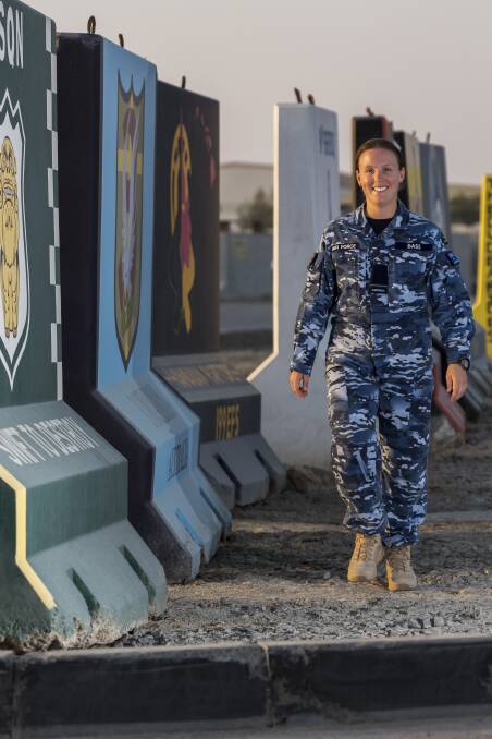ON TOUR: RAAF personnel capability officer, Flying Officer Amelia Bass, from Nelson Bay, walks past the painted T-Walls at the main air operating base in the Middle East region during her deployment with Operation Accordion. Picture: Australian Defence Force