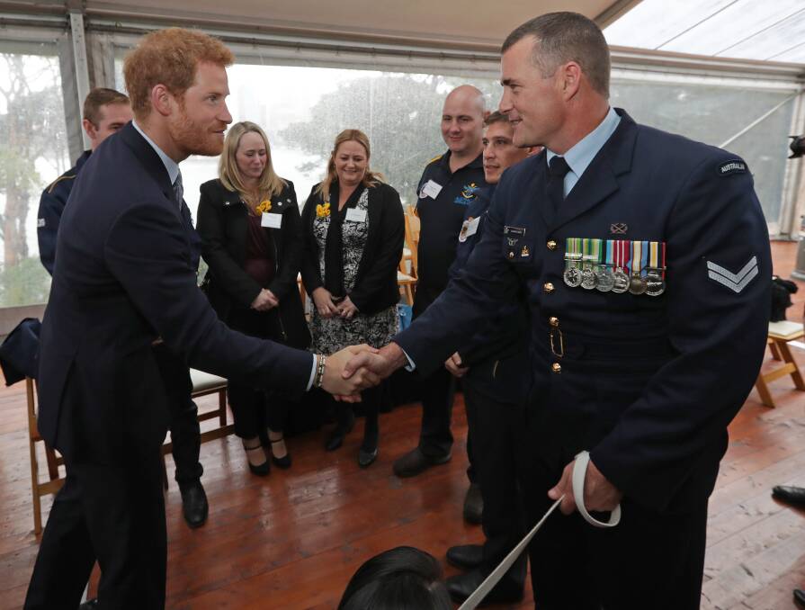 NICE TO MEET YOU: Prince Harry shaking the hand of Corporal Nathan Beck, holding the lead of retired military working dog Victory, at the launch of the Invictus Games in Sydney.
