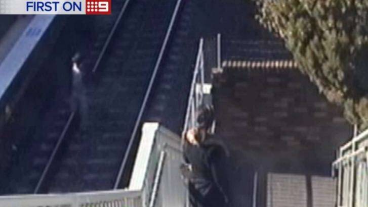 Grandfather running to avoid being hit by a train after rescuing his baby granddaughter who fell onto train tracks at Wentworthville train station. Photo: Nine News