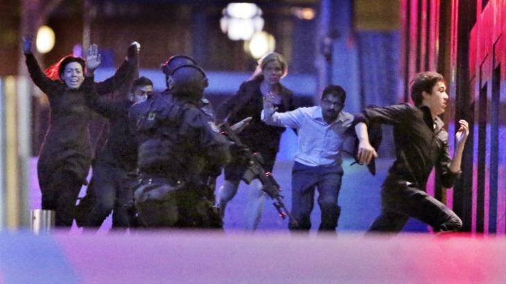 2.03am: Five hostages run from the Lindt cafe towards Special Operations Police. Photo: Andrew Meares