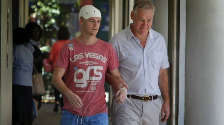 One-punch attack: Michael McEwen leaves hospital with his father, Robert. Photo: Dean Sewell
