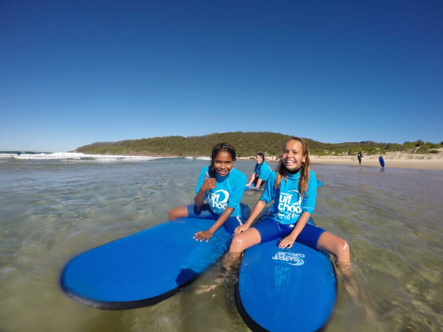 SMILES SAY IT ALL: Two of the children who were given the opportunity to go surfing for the first time in their lives with Port Stephens Surf School recently.