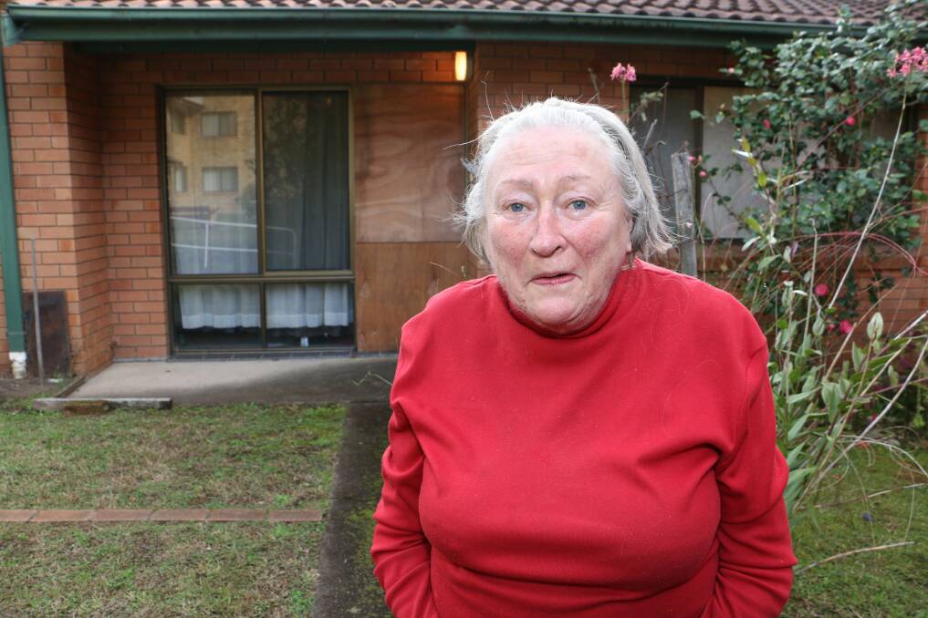 DISMAYED: Margaret Davis, in front of her neighbour's boarded-up door.