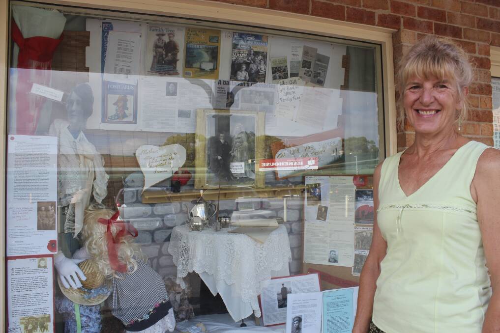 HARKING BACK: Jenny Little of the Tea Gardens Hawks Nest Family Research Group with the latest window display. Picture: Nathalie Craig