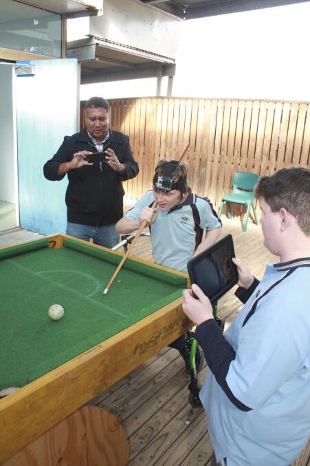 ACTION: Guy Perrine instructs Tomaree students Jason Penman, 16, and Jesse Beaven, 15, in the art of filming around a pool table. Picture: Stephen Wark