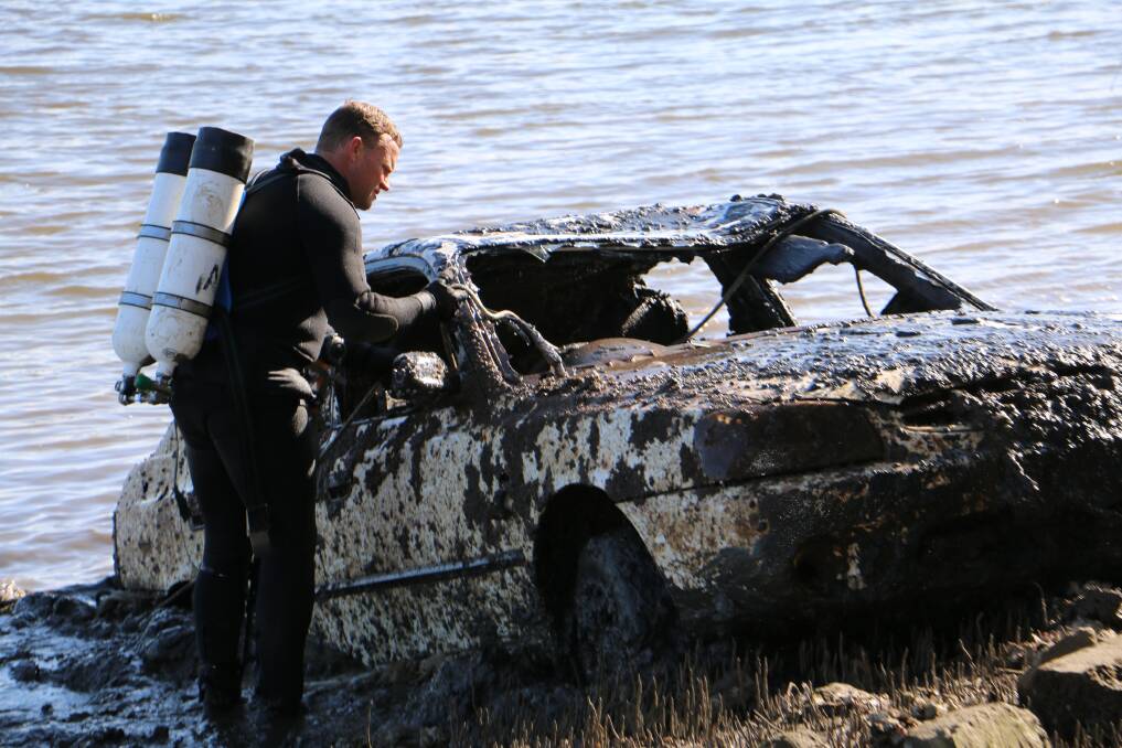 FOUND: A diver from police Operation Ahoy with one of the four cars recovered from the Hunter River at Tomago on Tuesday. Pictures: Ellie-Marie Watts.