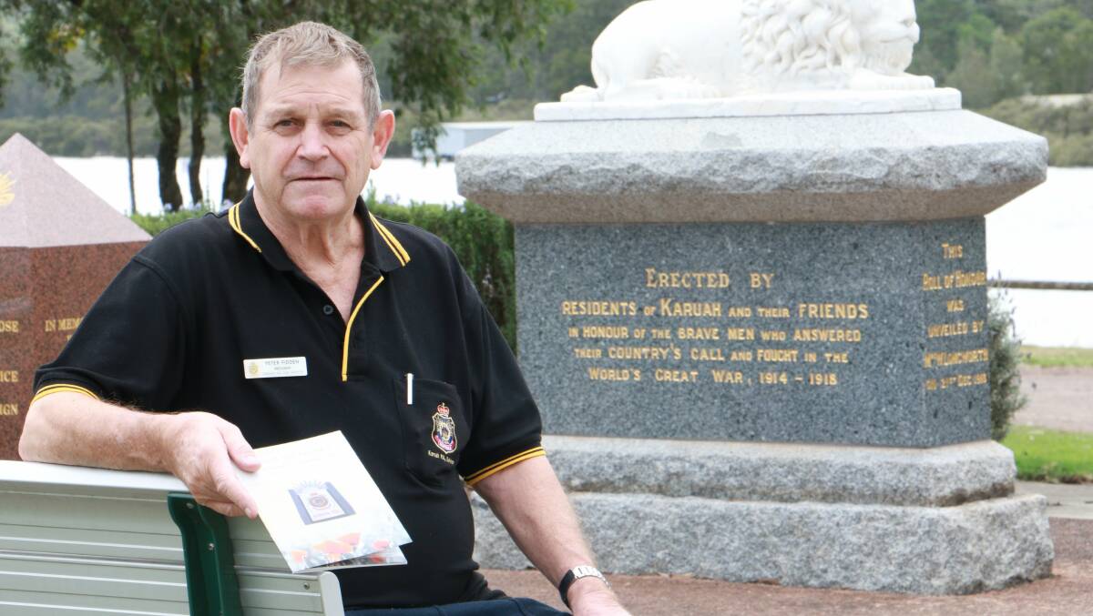 LEST WE FORGET: Karuah RSL Sub-Branch president Peter Fidden at the town’s cenotaph with a copy of its commemorative booklet.