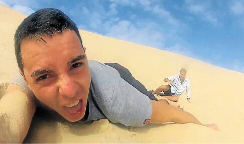 SAND SANDWICH: A French filmmaker takes a spill while sandboarding down a Port Stephens dune. Picture: YHA Australia