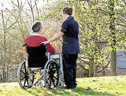 Nurse outdoors with patient in wheelchair , essentra