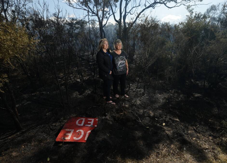 Burned Out: Loretta Clarke and Trina Hampson at Tanilba Bay, where fire destroyed large areas of bush. Picture: Jonathan Carroll    
