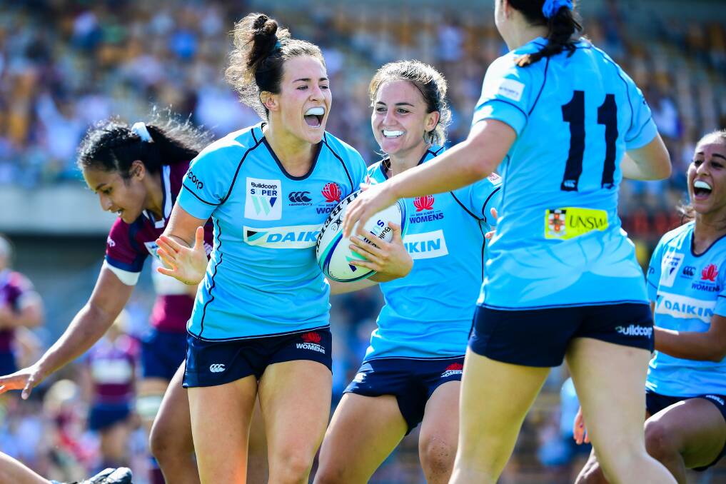 IN CONTENTION: Maya Stewart (left) is congratulated by Katrina Barker (centre) after scoring her first try for NSW in the Super-W. Both players are in the Wallaroos train-on squad. Picture: AAP