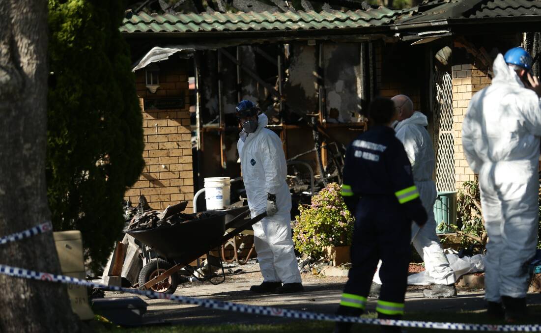 DEVASTATING: Emergency services at the scene of the house fire at Raymond Terrace on Saturday. A man has been charged with murder.