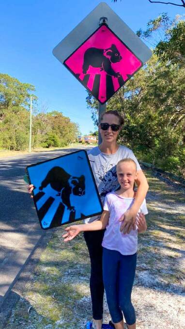 ADVOCATE: Casey Freeman with daughter Ruby and their koala signs which Daryl Ryan from One Mile says are a welcome addition to the area.