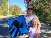 ADVOCATE: Casey Freeman with daughter Ruby and their koala signs which Daryl Ryan from One Mile says are a welcome addition to the area.