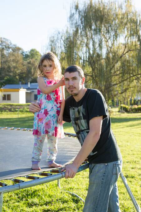RED LIGHT: Ryan Baker with his daughter Ociana in the backyard of their Salt Ash home. He is struggling to get a business loan because his house is located in Williamtown's contamination 'red zone'. Picture: Max Mason-Hubers