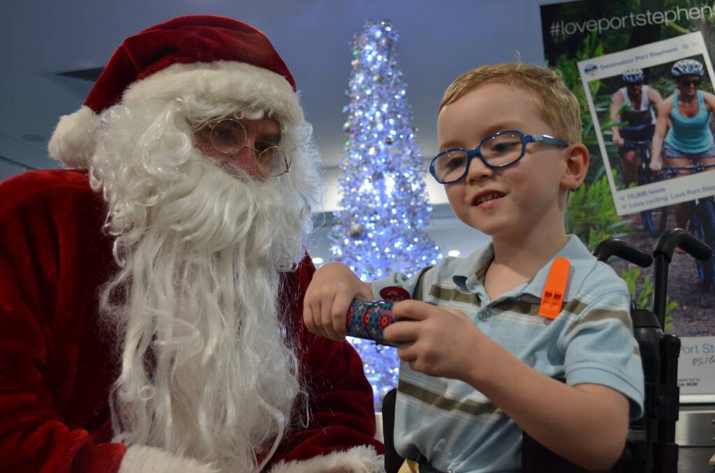 THANKS SANTA: Spencer Clarke, 5, of Thornton receives a kaleidoscope from Santa who made a special trip to Newcastle Airport on Monday with gifts for Variety Children's Charity. Picture: Sam Norris 