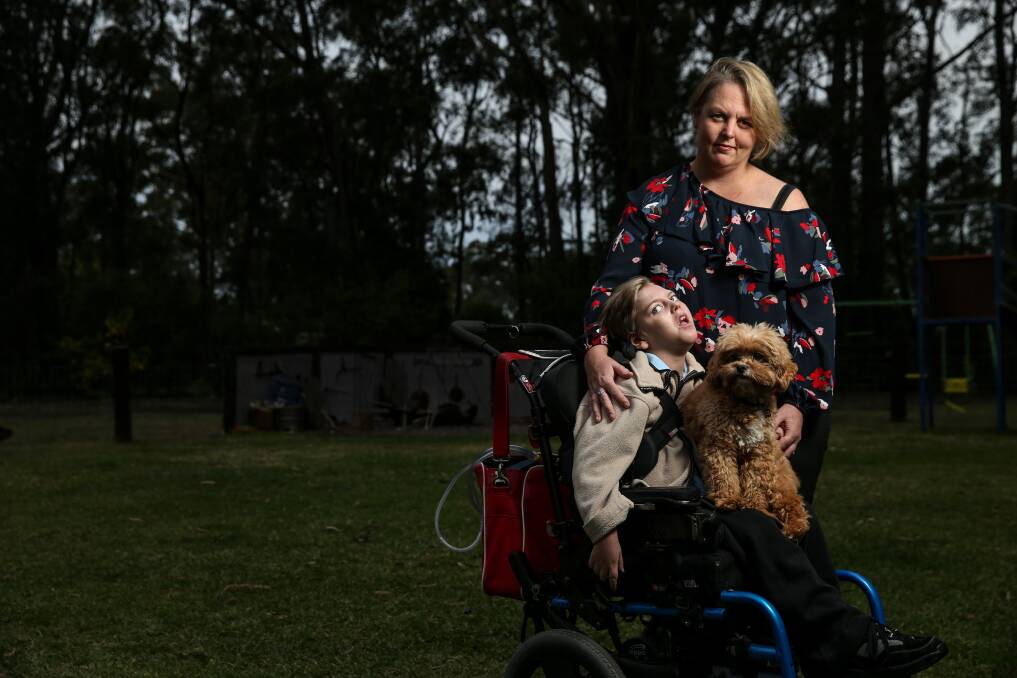 Support: Medowie's Braith Wall, with his mother Kellie, and their dog, Boots. They have been fighting a decision to have his NDIS funding slashed. Picture: Marina Neil
