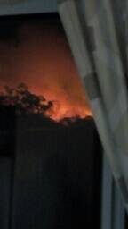 TOO CLOSE FOR COMFORT: The view of bush burning at Box Beach from the dining-room window of a home at Shoal Bay about 6.30pm. 