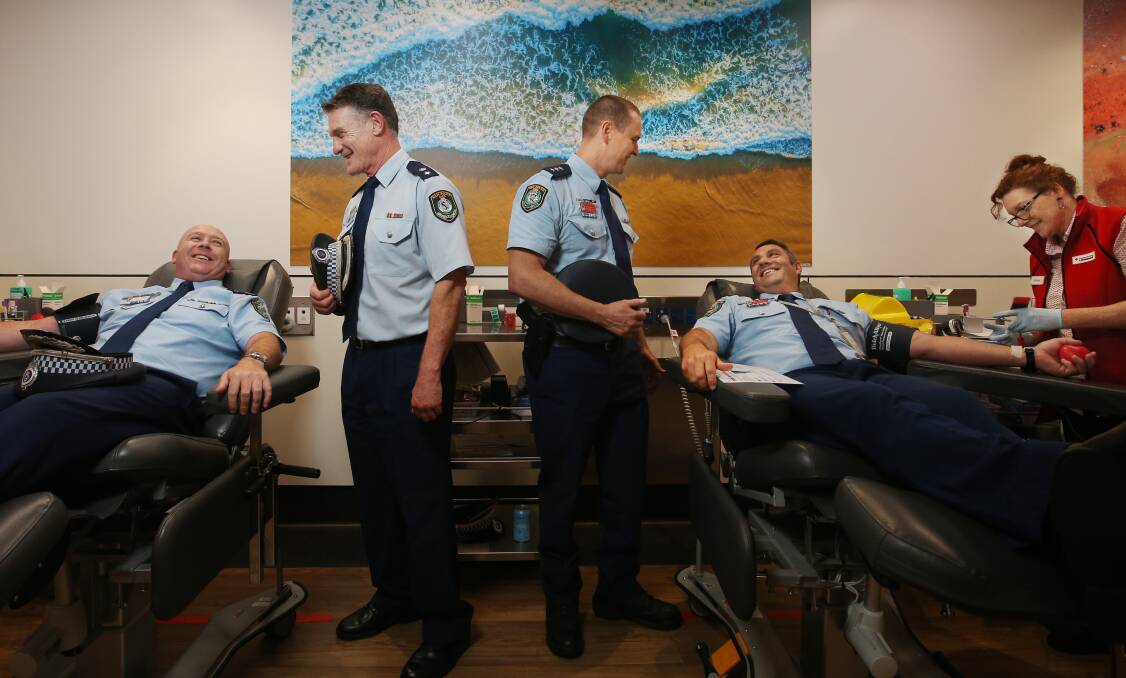 Assistant Commissioner Peter McKenna, Detective Superintendent David Waddell, Detective Inspector Matthew Crotty and Inspector Mitchell Dubojski donate blood at Lifeblood Newcastle, as phlebotomist Shirene Donnelly inserts a needle. Picture by Simone de Peak