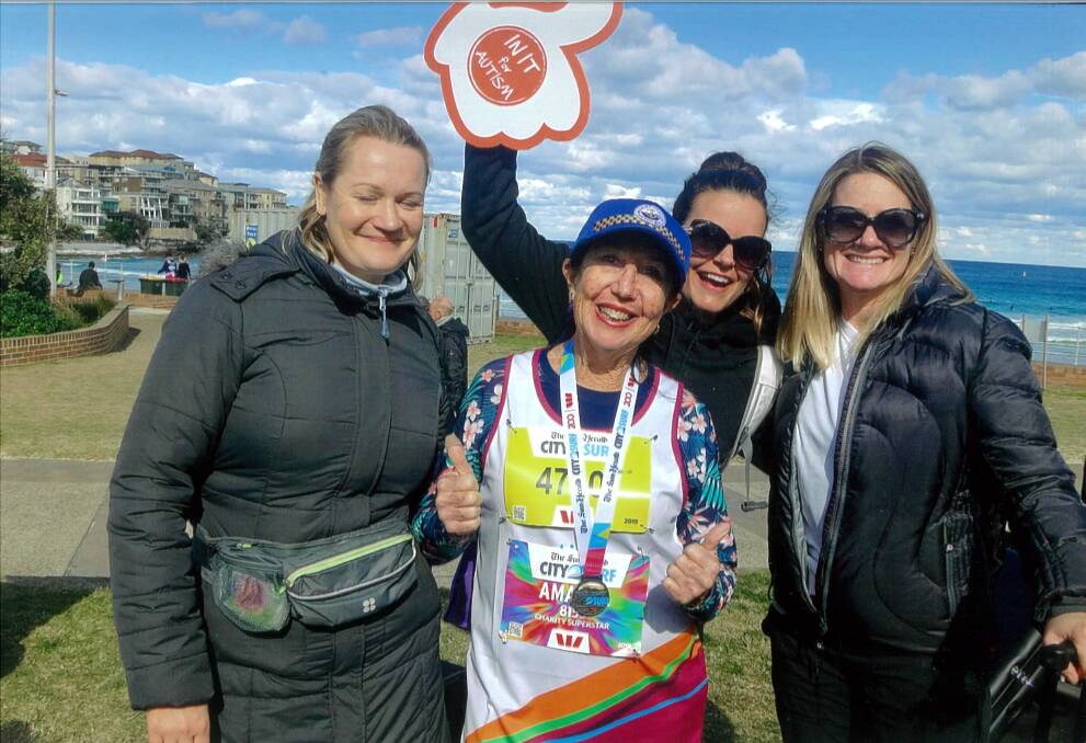THUMBS UP: Anna Bay grandmother Amanda Sutherland surrounded by her Autism Australia fundraising team at the City2Surf finish line. Pictured: Supplied