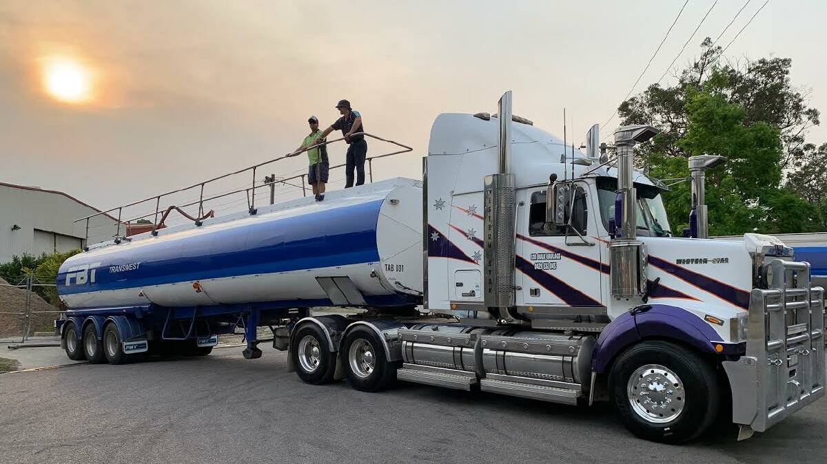 WATER CONVOY: Contractors Brett Ritter and Craig Gray atop one of three rigs which delivered 500,000 litres of water to drought-affected farmers out west. Picture: Supplied