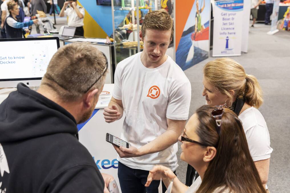 NEW APP: Anna Bay's Mike McKiernan, centre, showcasing his app, called Deckee Boating, at a recent trade show for boaters. Picture: Supplied