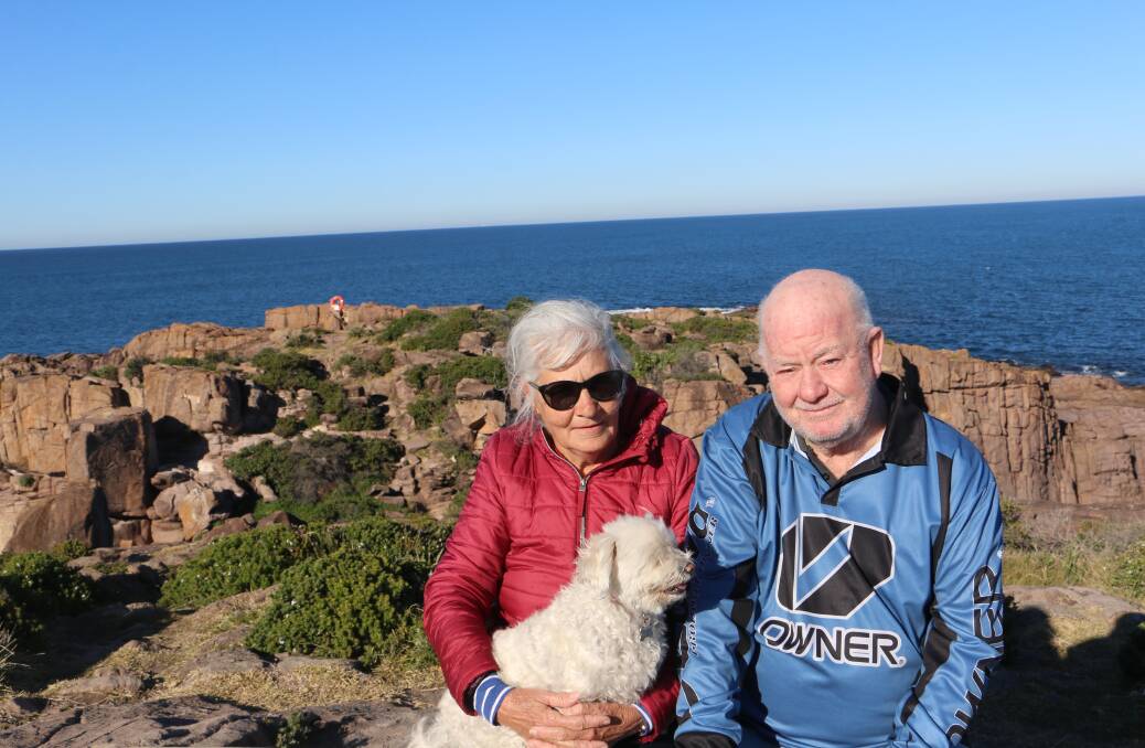 GUARDIAN ANGELS: Boat Harbour's Marcia and Ray Smith, dog Bella and the orange angel ring overlooking the rock platform where three people were washed into the ocean.