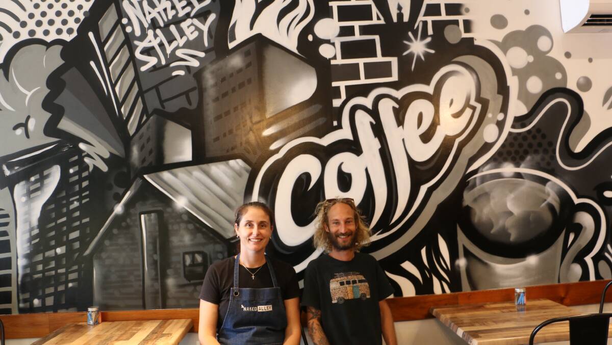 Rhys Fabris with cafe manager Krysten Ciampi and the inside wall mural.
