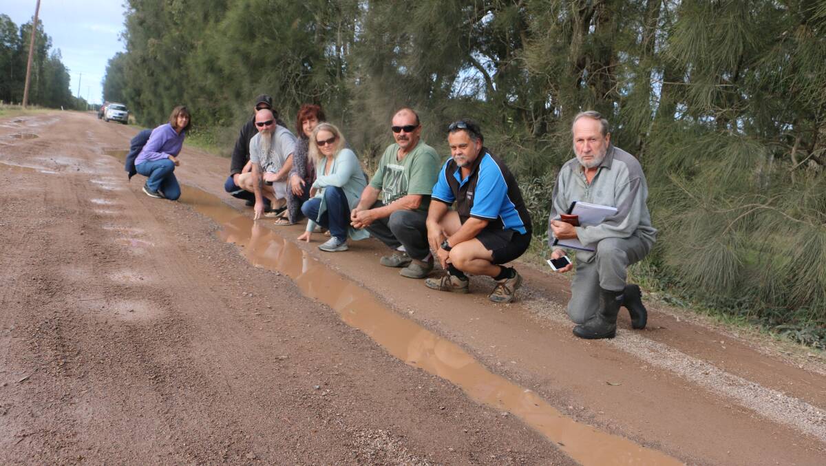 ENOUGH IS ENOUGH: Swan Bay residents inspect the damage to Swan Bay Road after the recent rains.