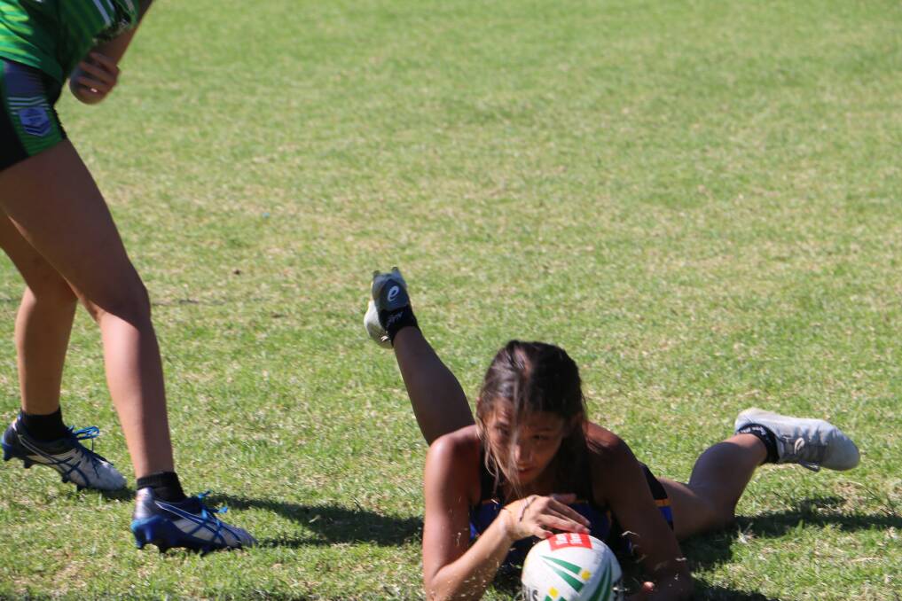 TOUCH DOWN: Nelson Bay's girls on their way to winning the grand final at Tomaree touch fields on Sunday afternoon.