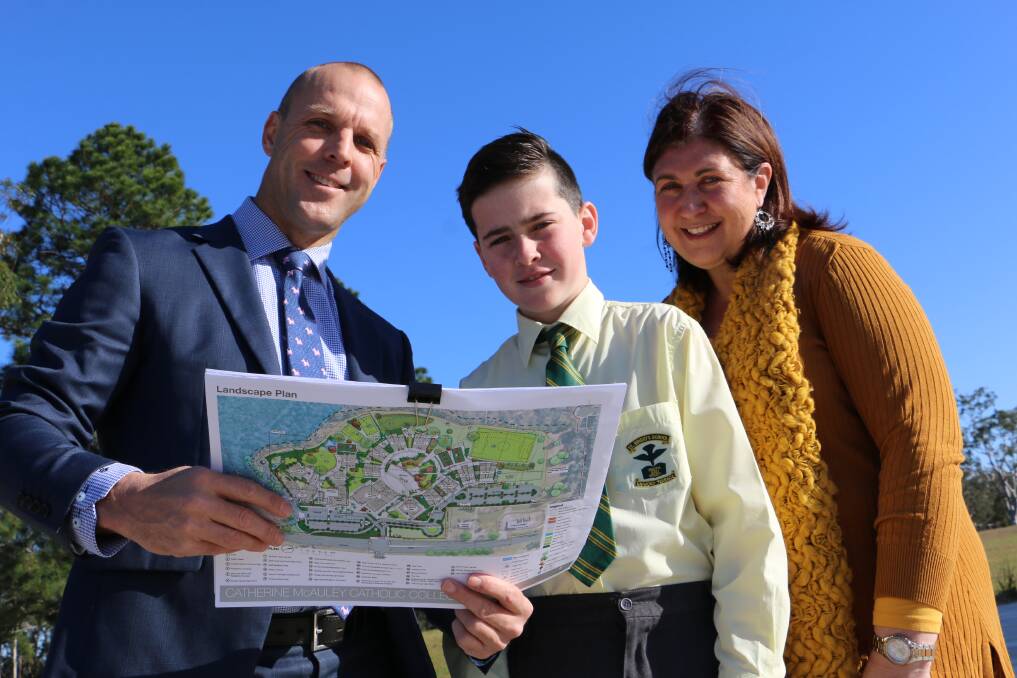 PLANS: St Brigid's Year 6 student Jonah Malone, aged 11, inspects plans for the Medowie college with his mum, Monique Malone, and college principal Scott Donahoe.