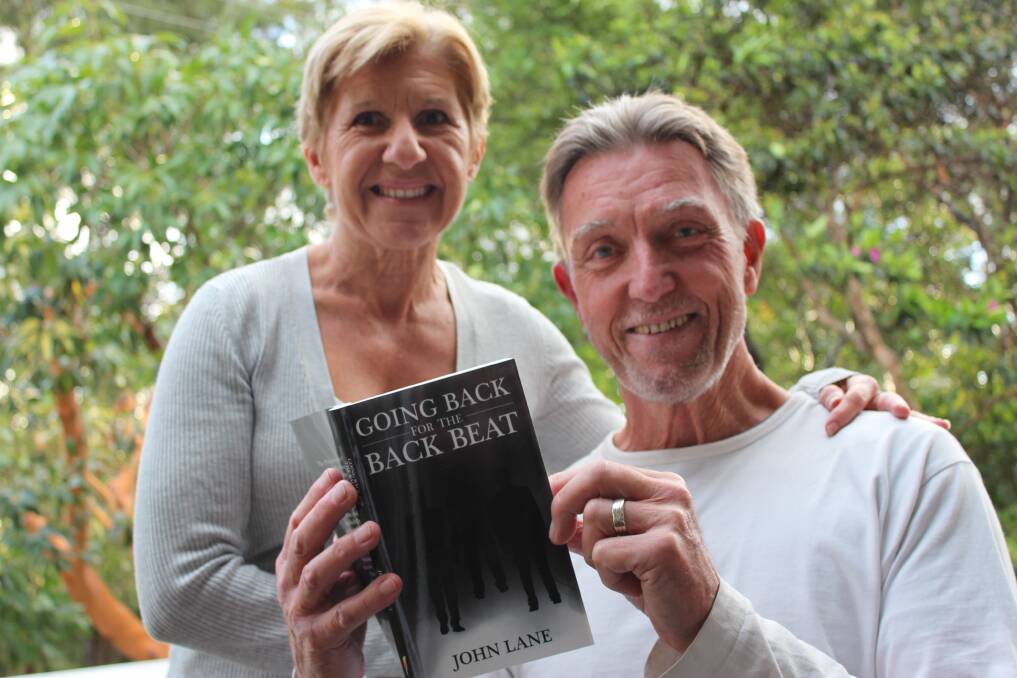 PUBLISHED: Surfer turned author John Lane with his wife Mary at their Nelson Bay home and the book Going Back for the Back Beat.